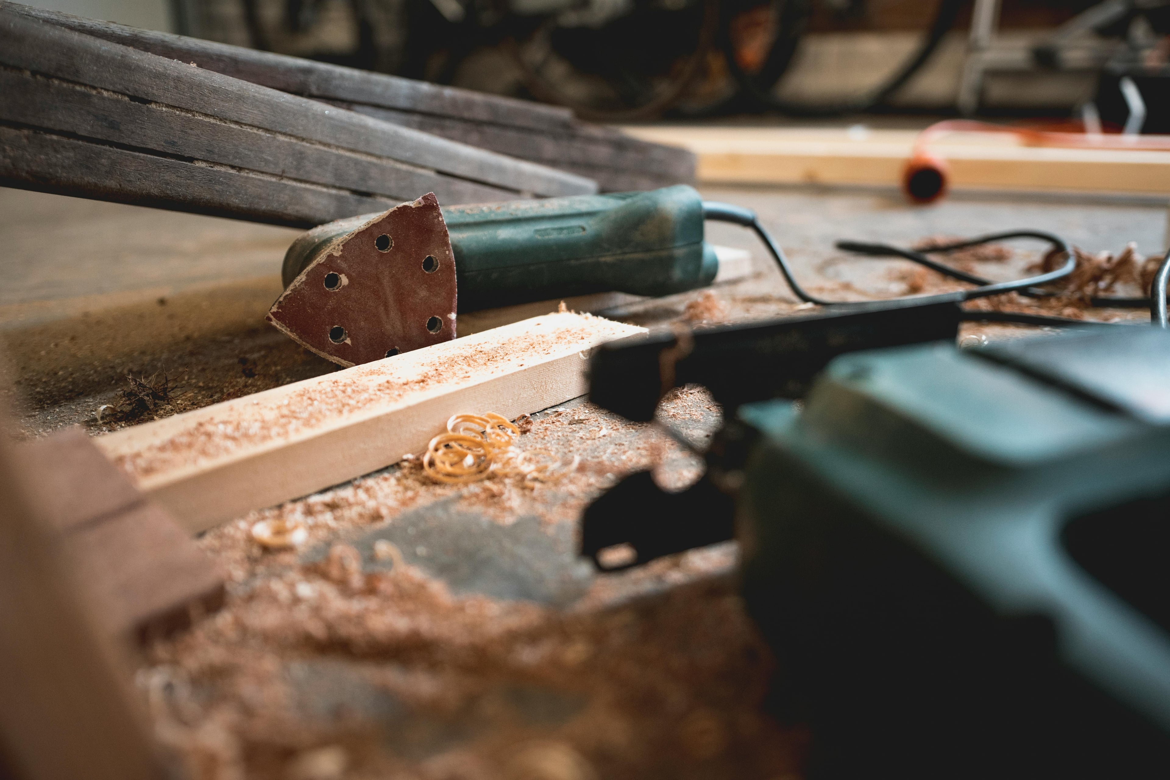 Professionell snickeriarbeten - Close-up of various woodworking tools in a workshop, featuring wood shavings and equipment.